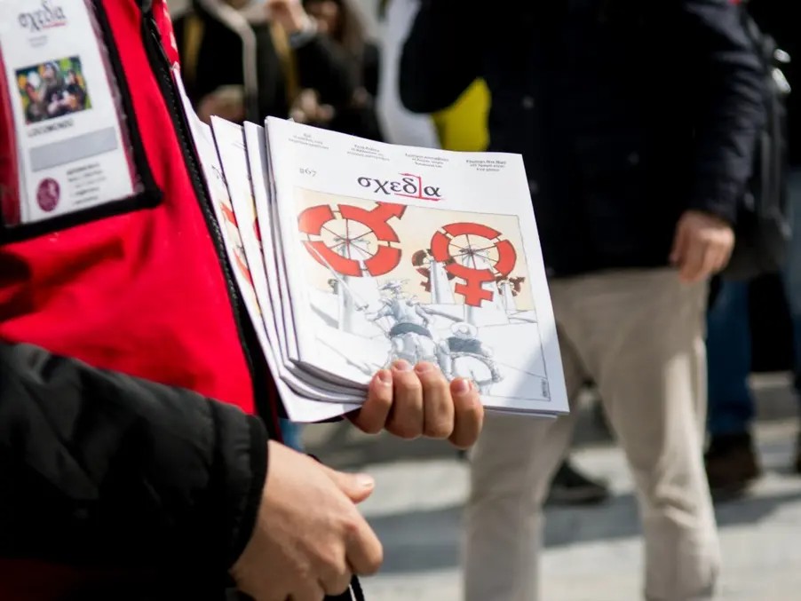 Πωλητής της σχεδίας κρατά τεύχη του περιοδικού