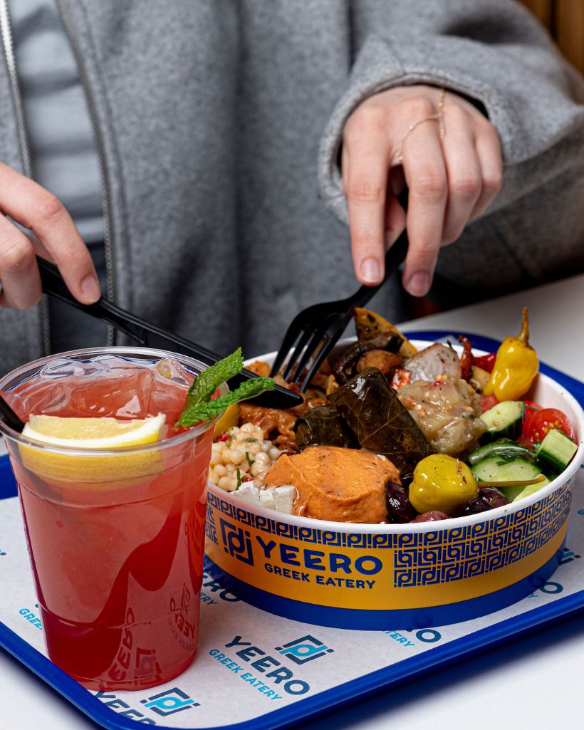 A loaded Yeero Greek bowl with a refreshing drink