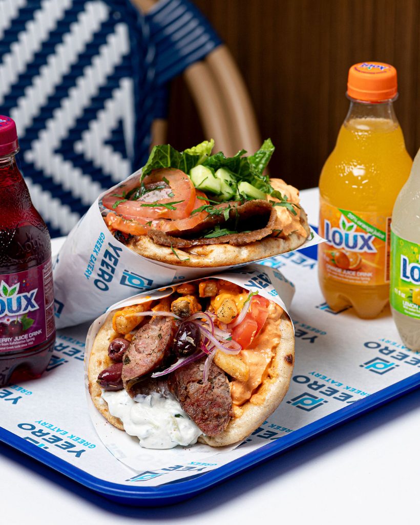 Two Yeero pitas with Loux Greek drinks on a tray